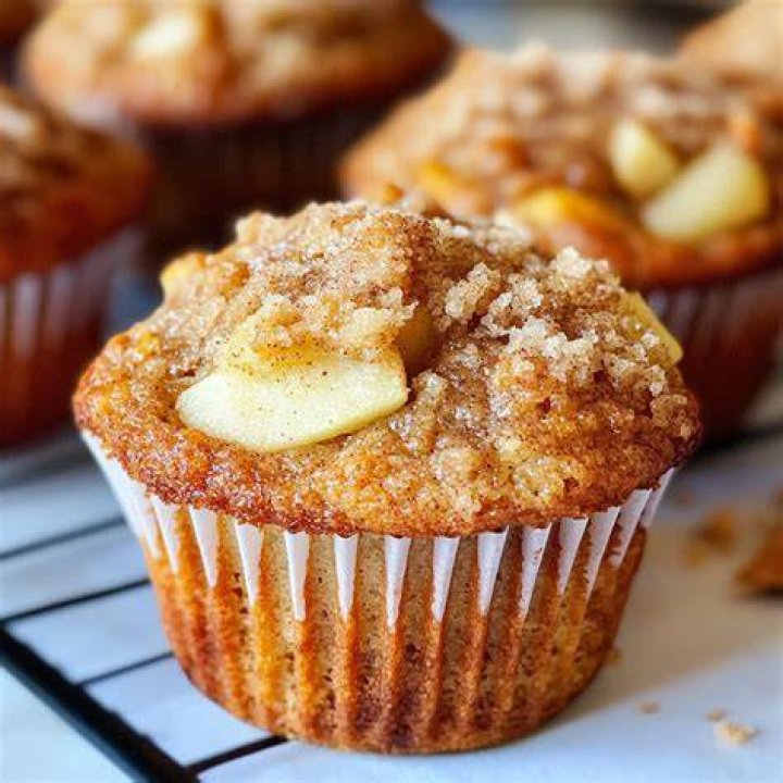 Apple cinnamon muffins on a wire rack topped with a cinnamon icing drizzle.