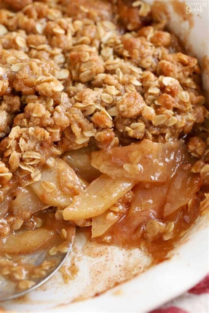 Closeup of an apple crisp in a white baking dish.