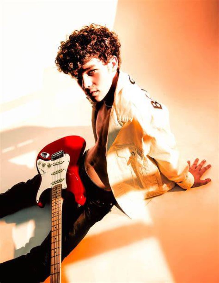  Hayden Summerall holding his guitar and posing for a photo. 