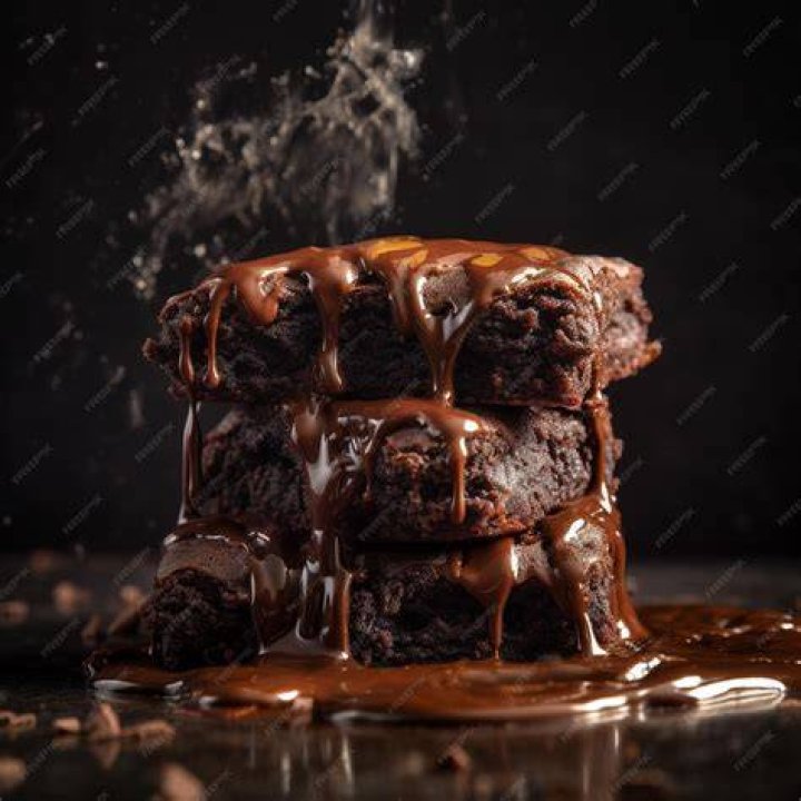 Stack of three brownies on a white plate.